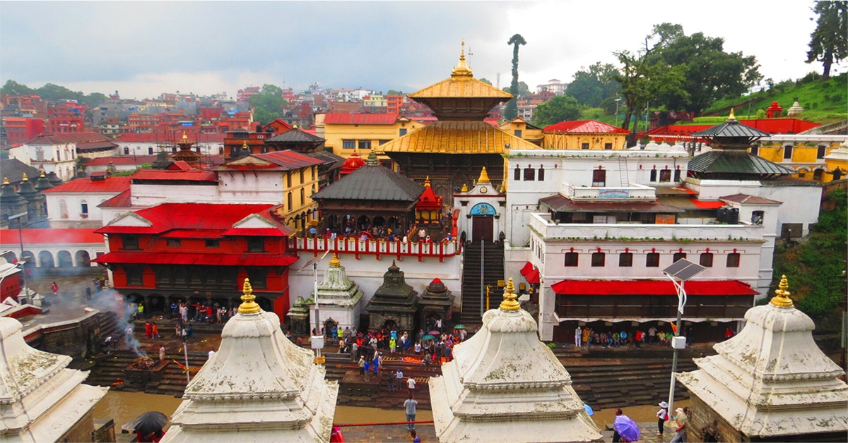 view of pashupatinath temple by the bagmati river with devotees